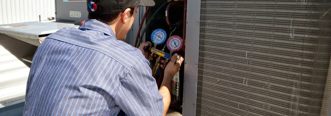 HVAC technician servicing a condenser unit in Abingdon